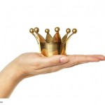 Goldene Krone auf einer ausgestreckten Hand